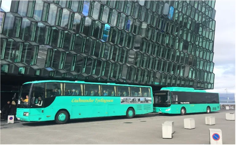 Green YES-EU electric buses parked in front of the Harpa hall in Reykjavik, Iceland